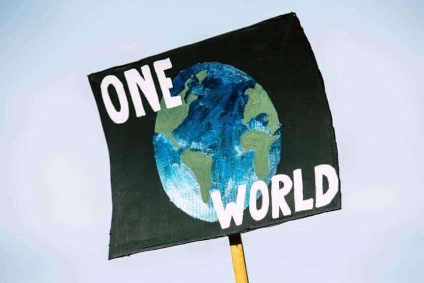 img 1926 1 Climate protest sign with the planet painted on a black background and the words one world