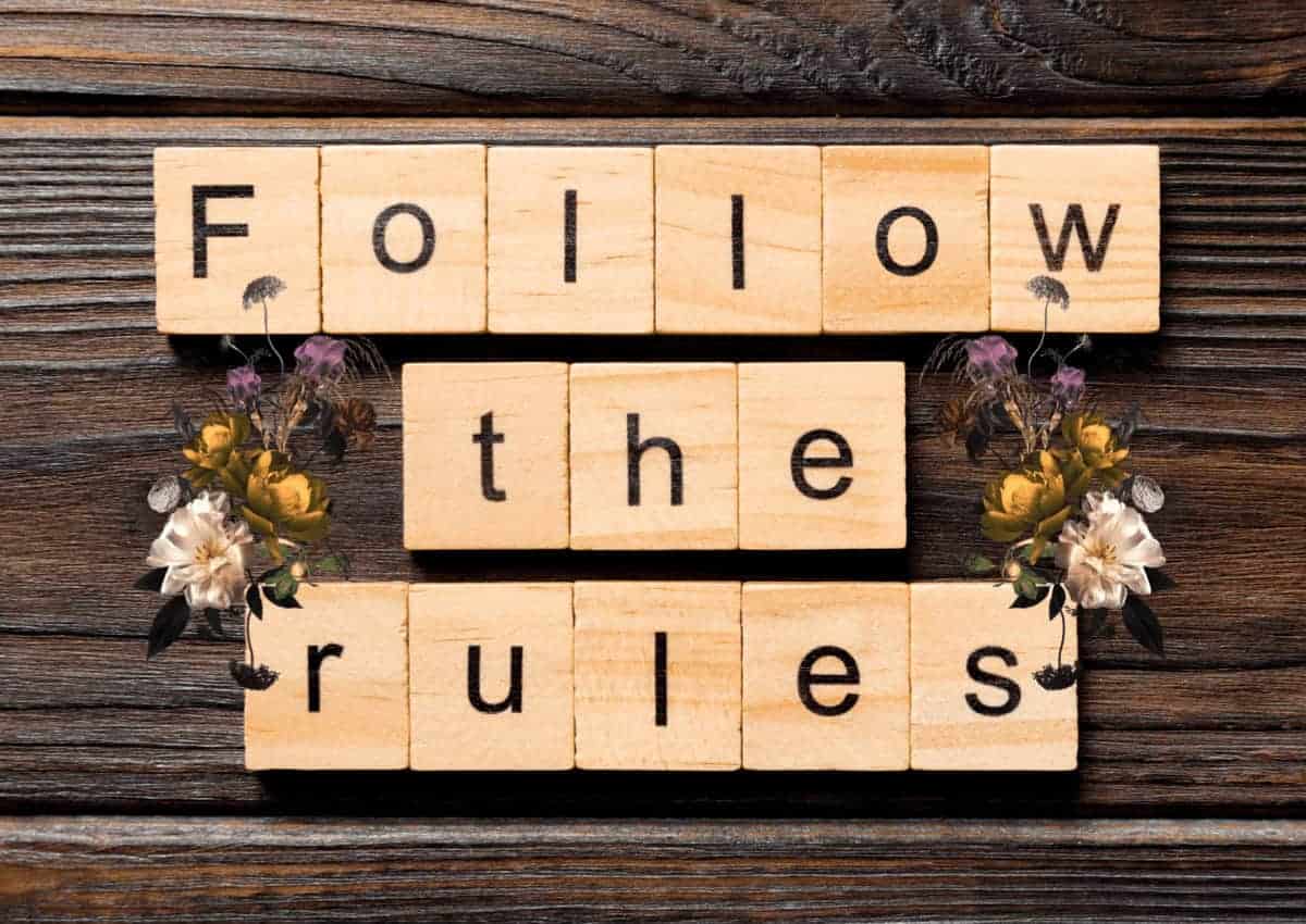 Submission guidelines header/wooden blocks on a darker wooden panel that spell out follow the rules