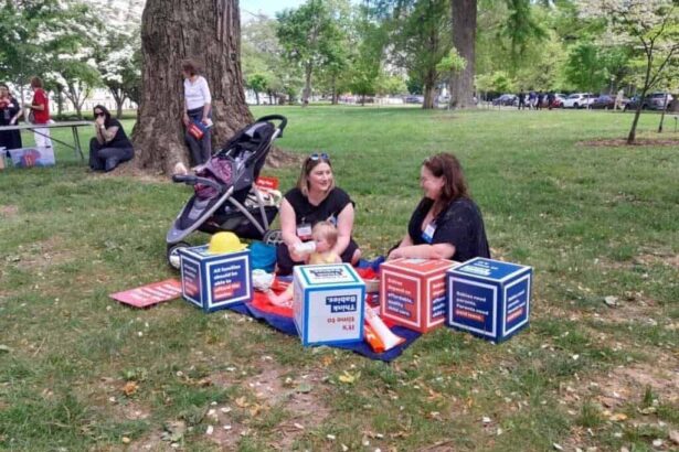 Mothers sit on the lawn while their kids are playing around them