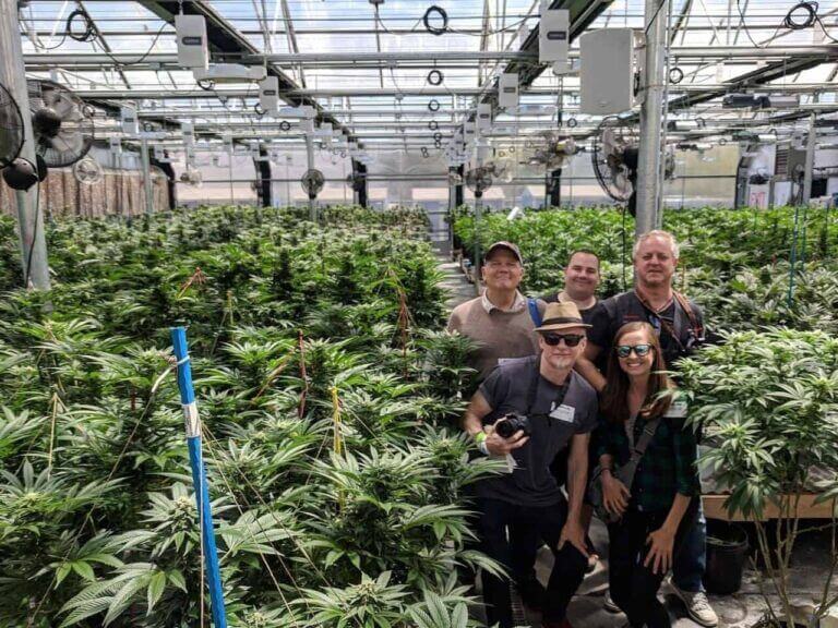 A group of cannabis tourists poses for a photo inside the euflora greenhouse grow facility in denver, colorado