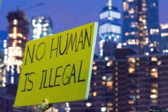 Immigration and daca protections protest sign that says no human is illegal