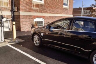 Electric vehicle parked at a charging station in a parking lot.