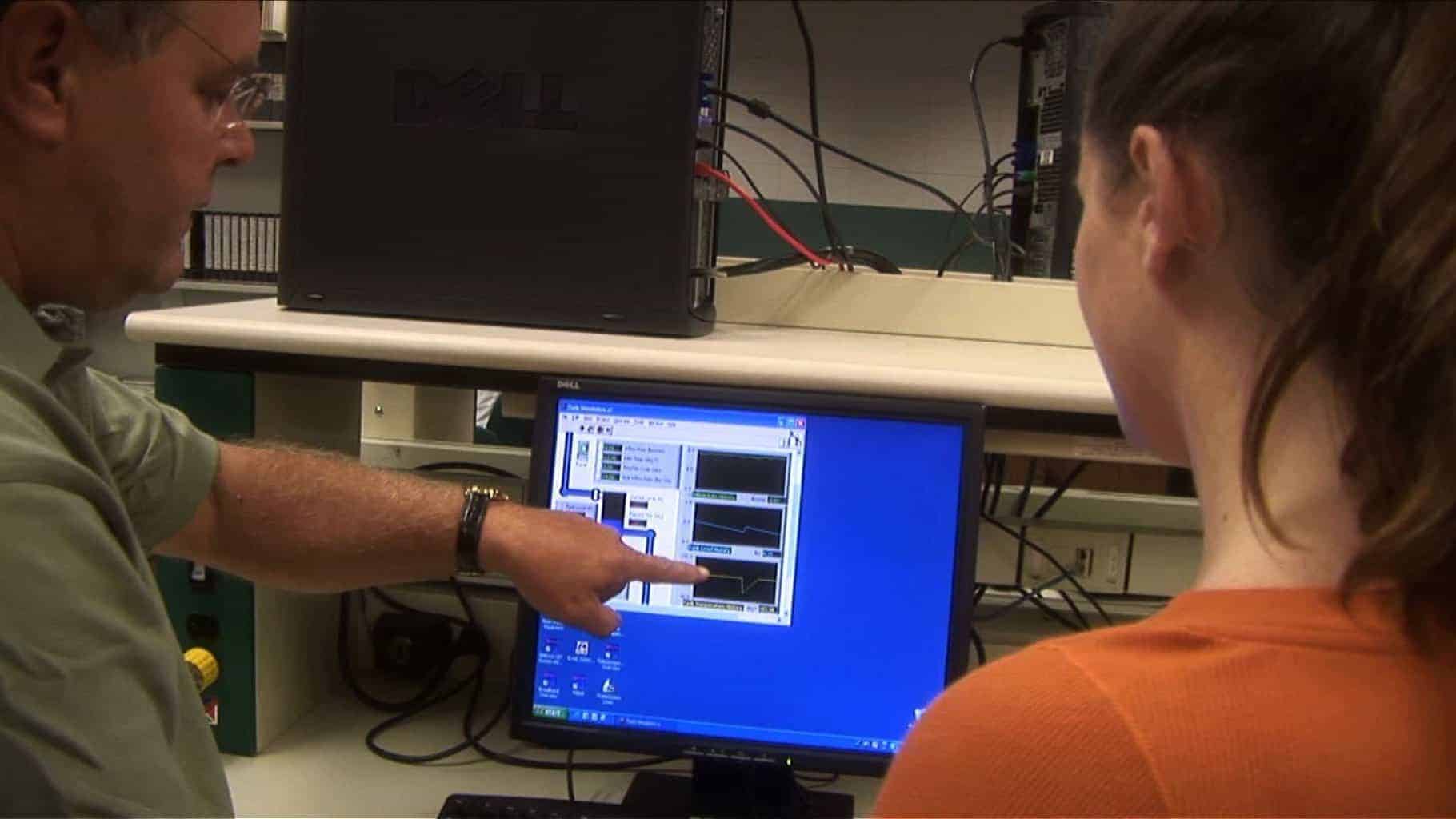 Computer techs looking at a monitor