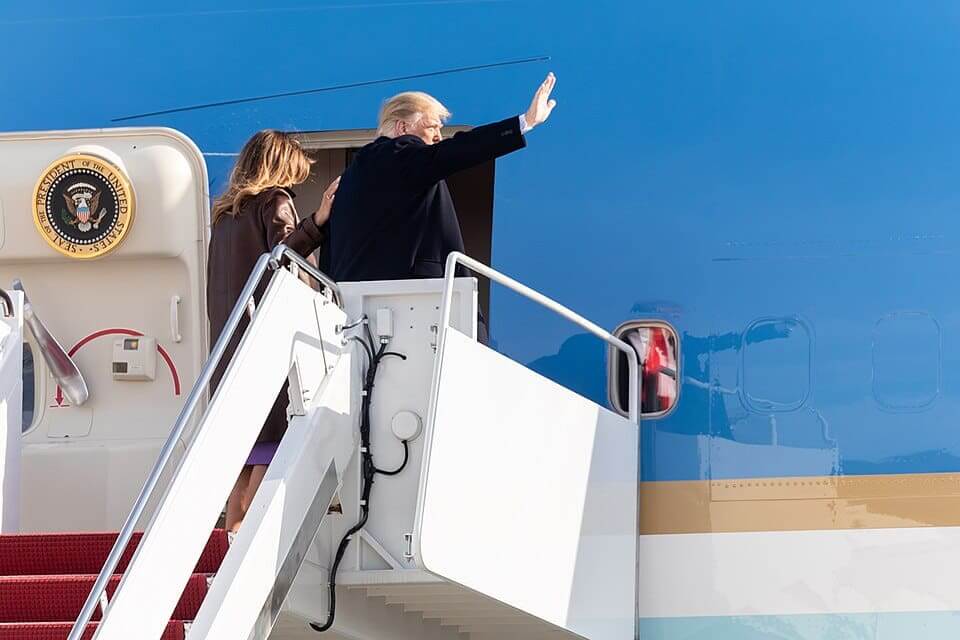 Trump waves while boarding jet