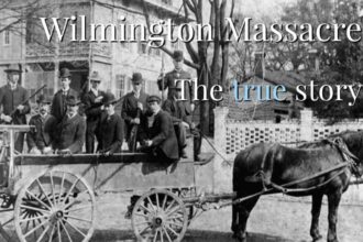 Black and white photo of white men in a horse drawn wagon with guns in 1898