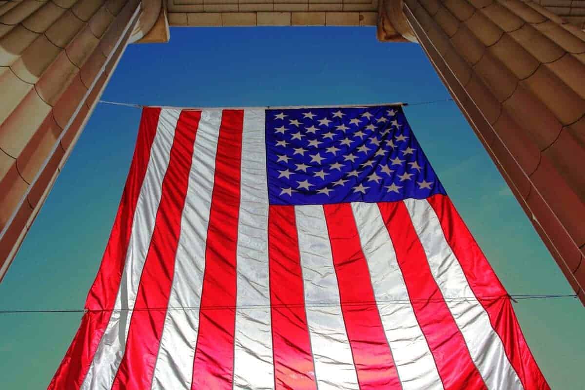 Underneath view of an american flag hanging with a blue sky in the background