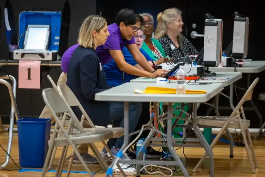 Presiding election judge Dina Patel, center, gives final instructions to election workers before polls open on Election Day at Parker Elementary in Houston.