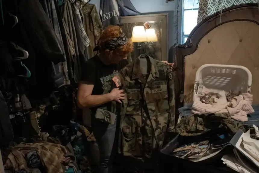 Sorcha Costigan holds up Jess Hampton’s army jacket in the bedroom of her home on Aug. 10, 2024 in Rosevine. “The goal is to get him out of jail, so he and I can both work on fighting this from the outside and get his name cleared,” Costigan said.