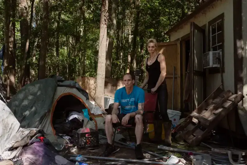 Rodger Pace, left, and Veronika Scheid next to the tent where they’re currently living after flooding struck parts of Harris County. Scheid said that if the property owner took a buyout she would have nowhere to go. 