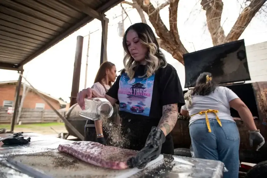 Simone See seasons ribs before putting them on the smoker at Hill Barbecue in Lubbock on Feb. 9, 2024.