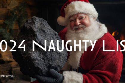 Santa holding a giant lump of coal by the fireplace
