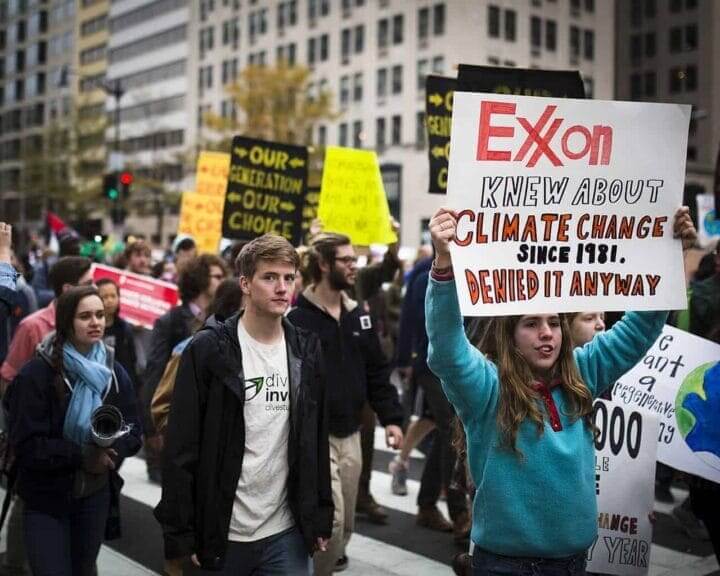 Climare denialism. Climate protest with signs that say, exxon jnew