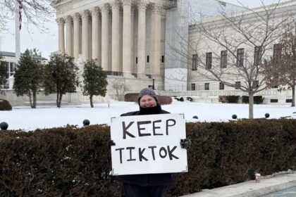 Woman holding a sign in front of the supreme court that says keep tiktok