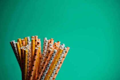 Colorful plastic straws on a green background