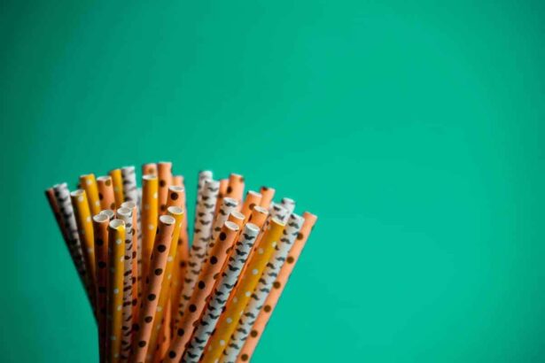 Colorful plastic straws on a green background