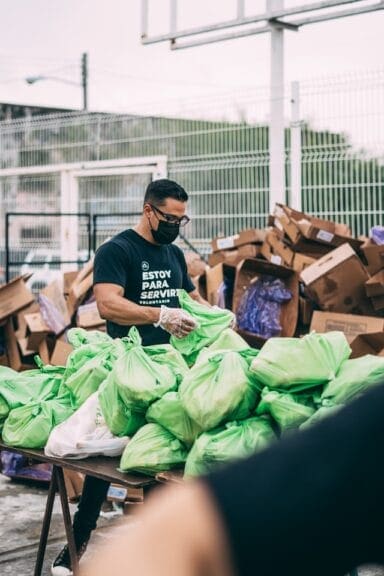A man volunteering for a nonprofit sorts through donations.