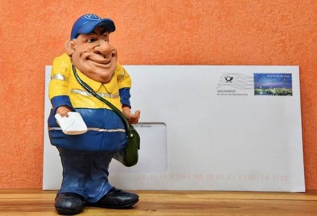 USPS mailman digital graphic standing in front of a letter with a stamp on it.