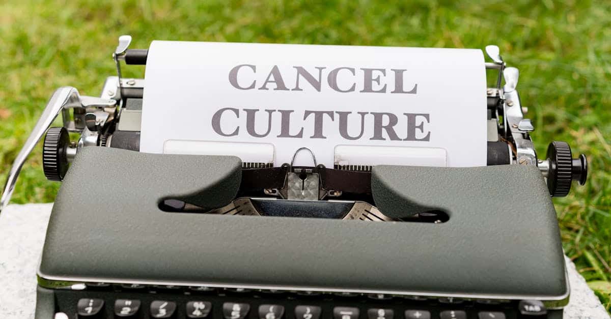 Retro typewriter with 'cancel culture' typed paper on grass background outdoors.