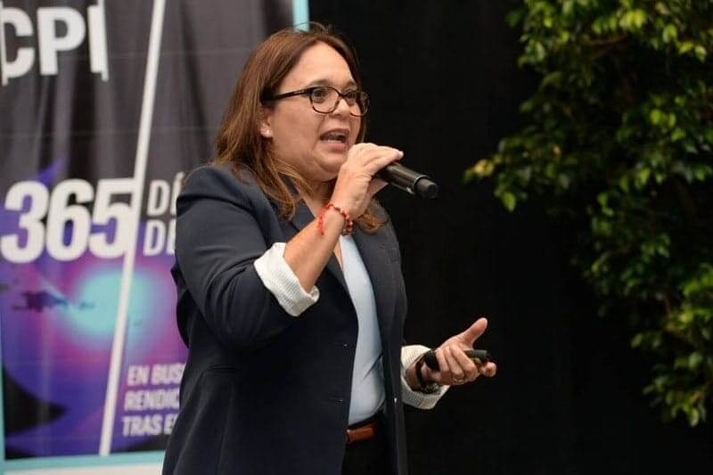 research in Puerto rico a woman speaks on stage holding a microphone.