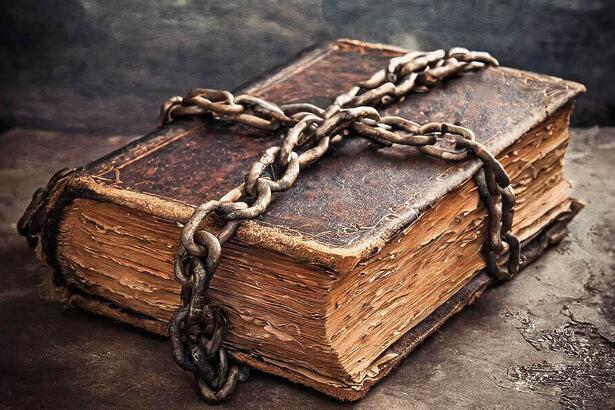 A vintage book wrapped in chains to signify banned books