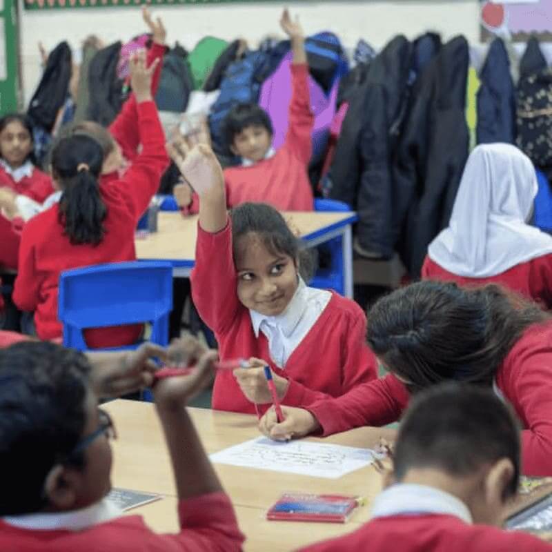 Progressive employers classroom of kids with their hands raised