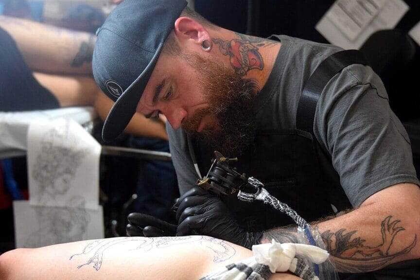 Tattoo artist giving tattoos to clients