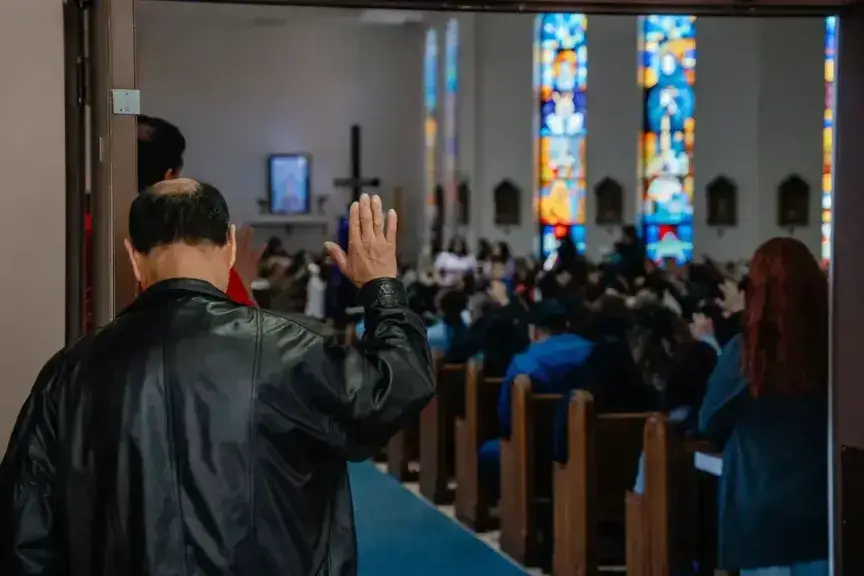 A man raises his hand in prayer during mass at nuestra señora de la paz, on april 6, 2025, in milwaukee, wisconsin.