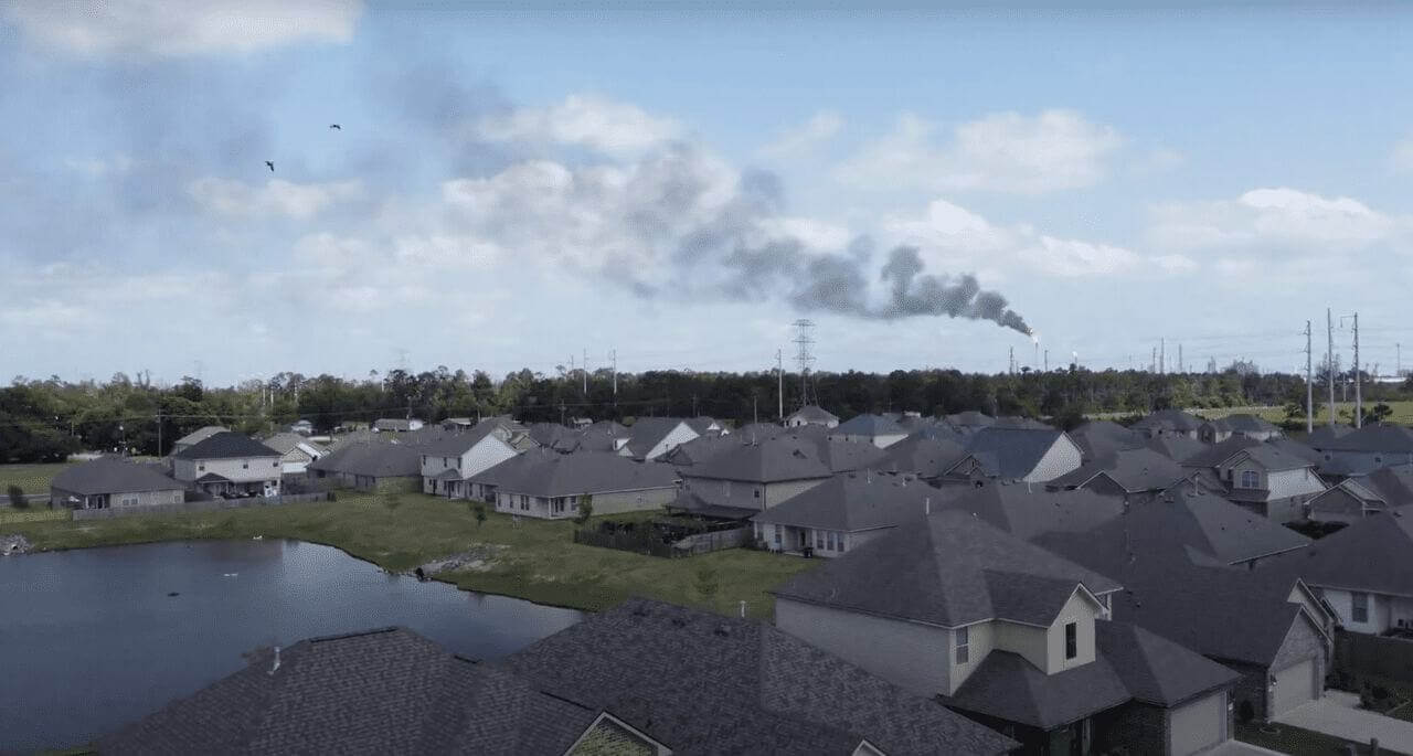 Louisiana neighborhood with factory in background. Community air monitoring ban