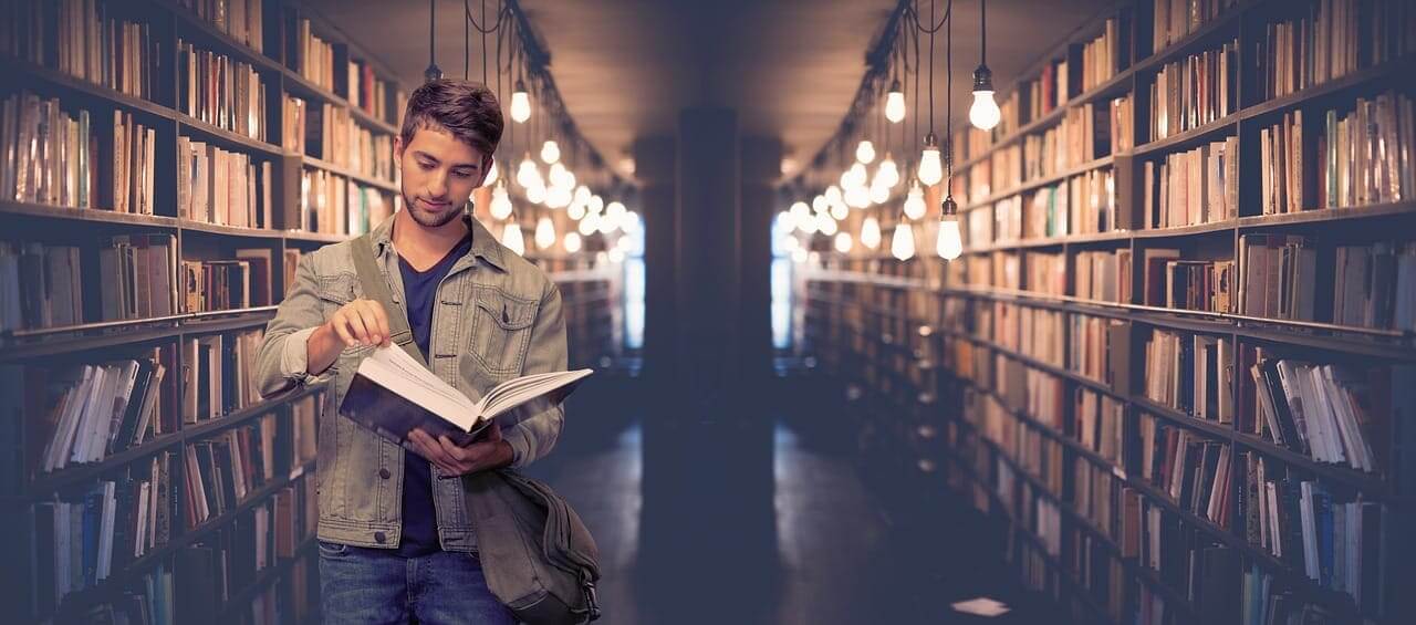 College student in a college library looking through a book