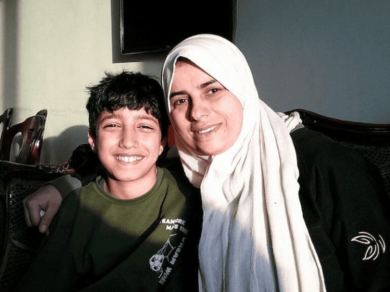 Gazan refugee mother smiling with her son.