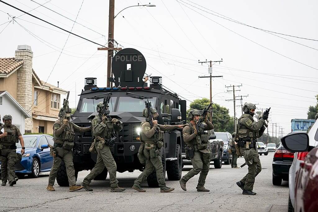 An ice raid in l. A. Under the posse comitatus act, the national guard is protecting ice as they conduct raids.