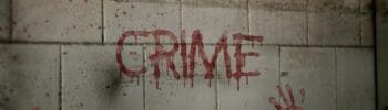 The word crime written in blood in a concrete wall.