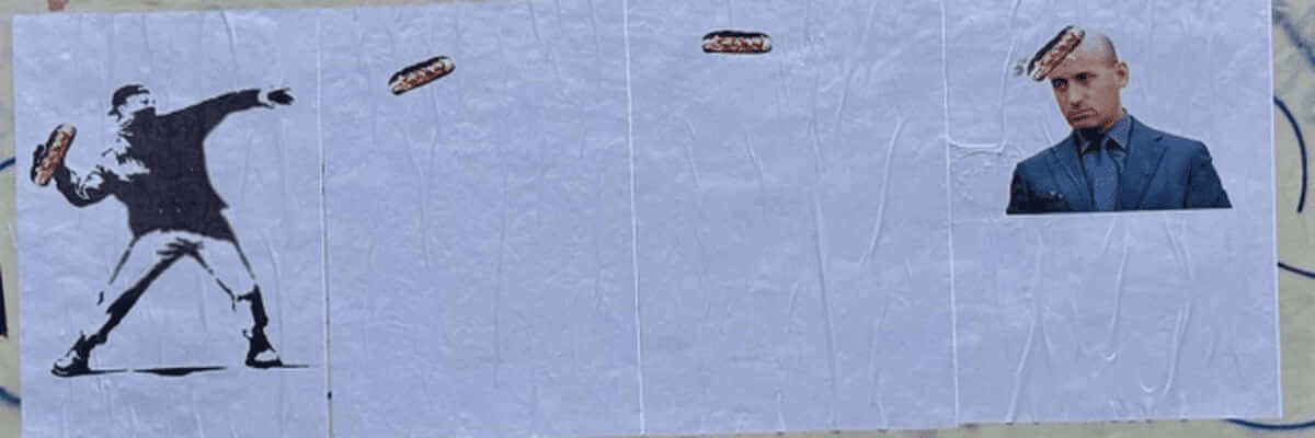 Banksy wall art of man throwing a sandwich at stephen miller