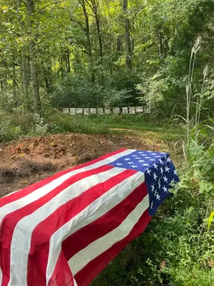 Example of a green burials casket with an american flag over it.