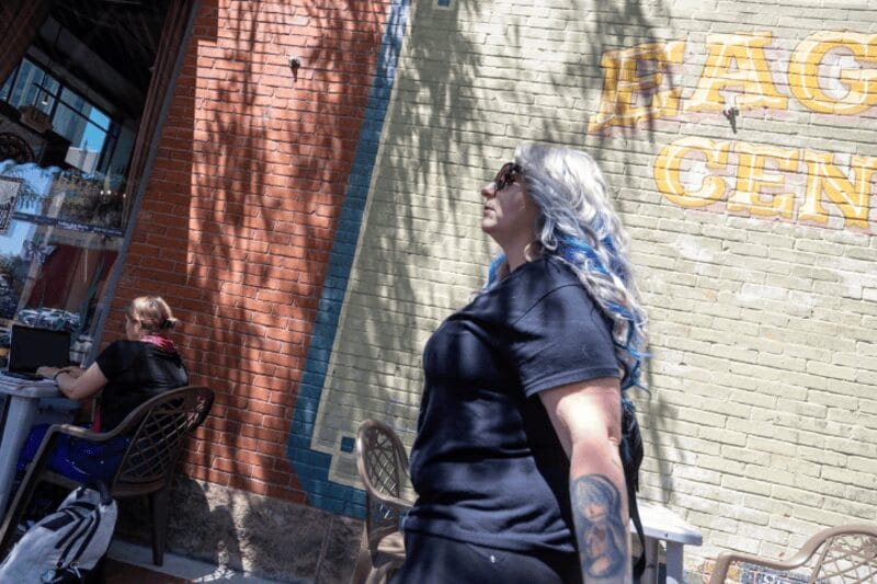 idaho women6 Woman with long blond wavy hair with blue streaks standing by a white brick wall