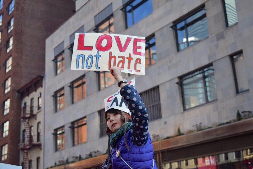 Girl at women’s march holding a sign that says love not hate