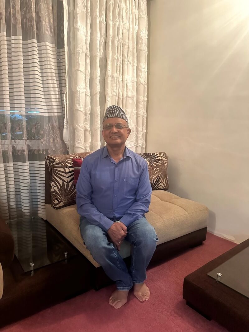 Man posing and smiling on a couch