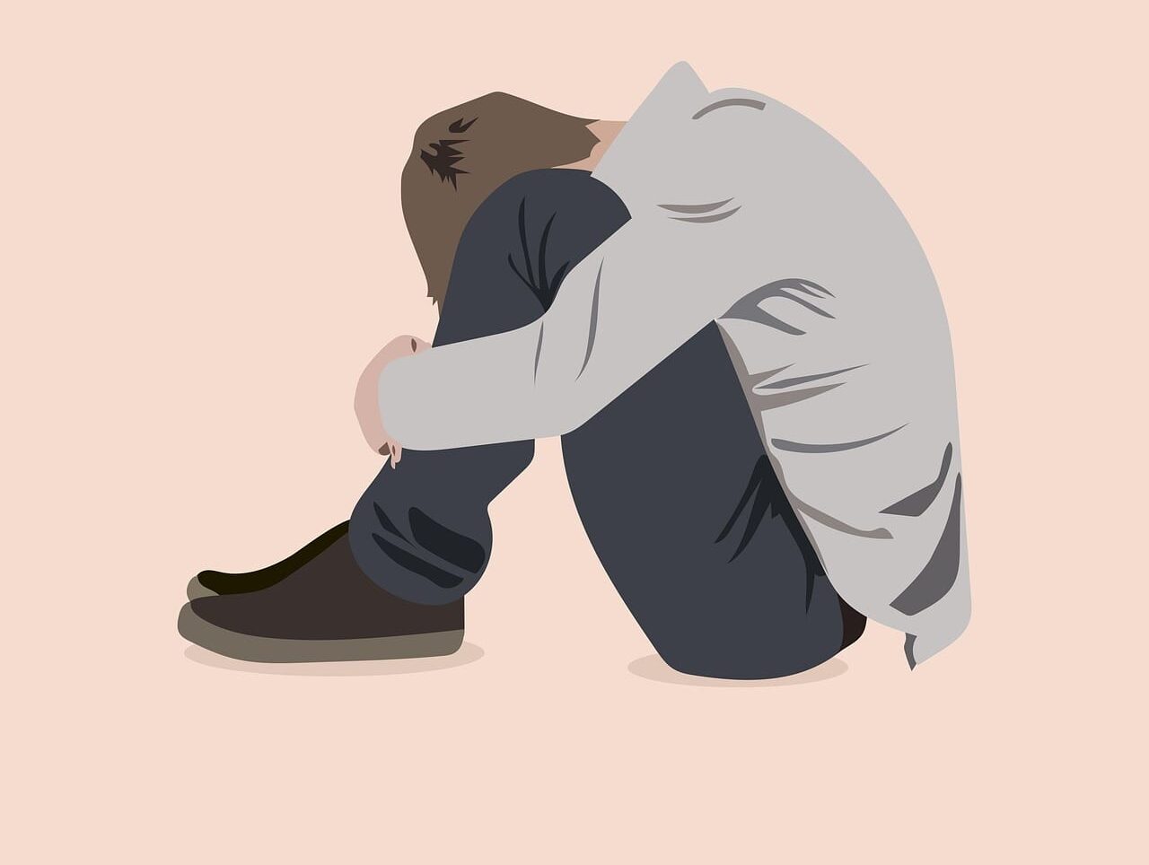 you are not alone e1770959846722 Kgbtq mental health resources. Illustration if a young man sitting on the floor with his head between his knees