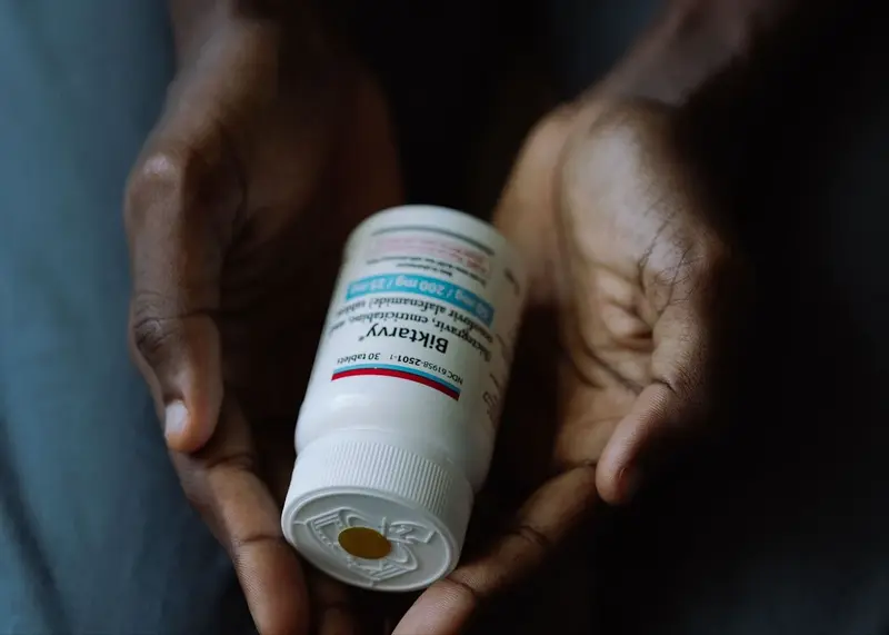 Man holding a bottle of hiv medication