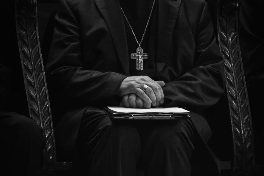 Catholic priests wearing cross necklace in black and white