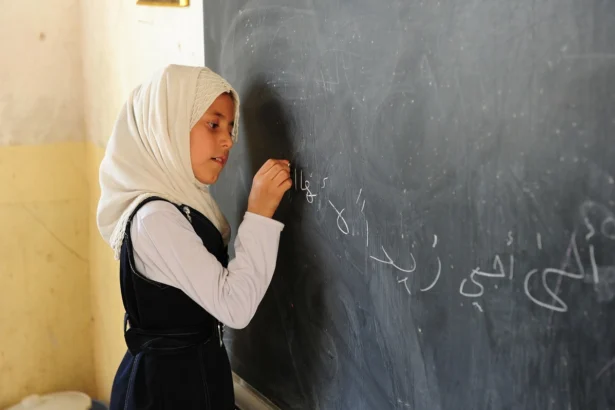 Girls school in iran. A girl writes on a chalkboard