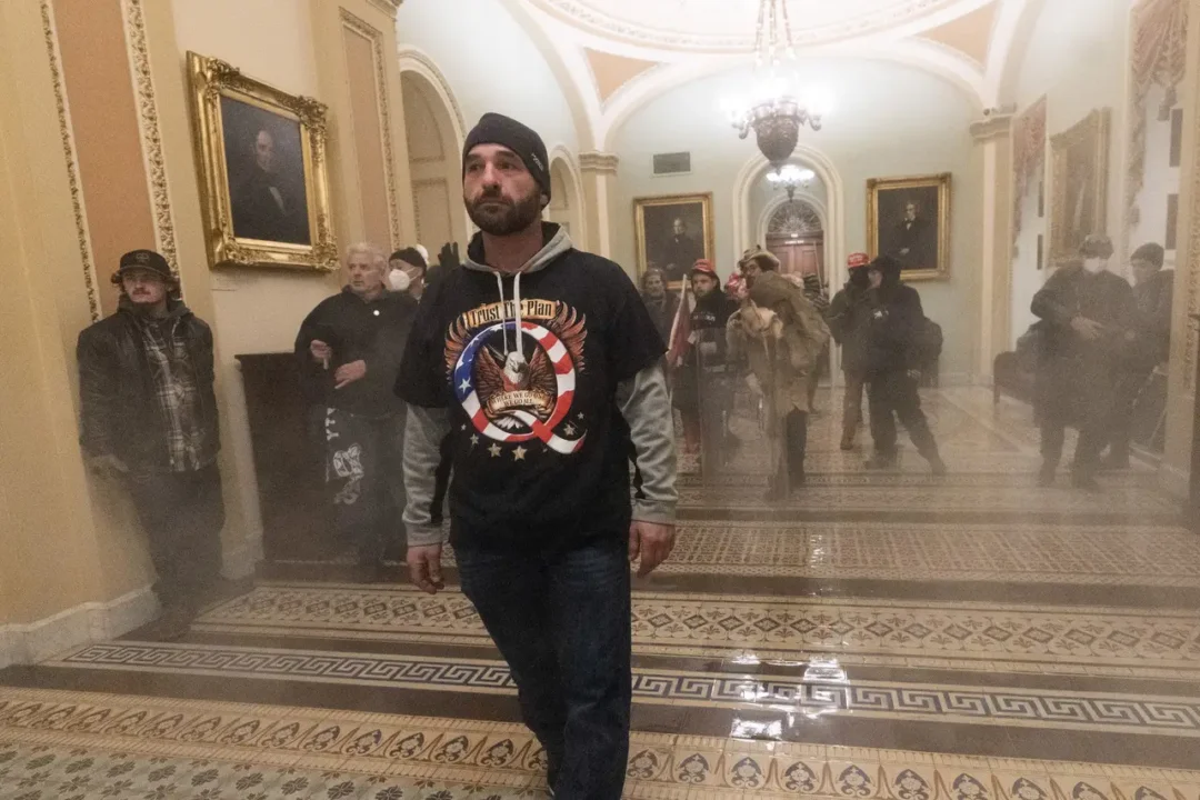Douglas jensen wearing a qanon shirt, believed in the deep state