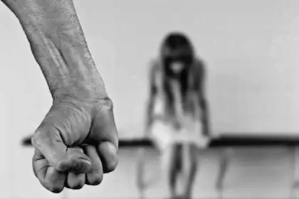 Black and white photo of a man’s fist and a woman in a blurred background