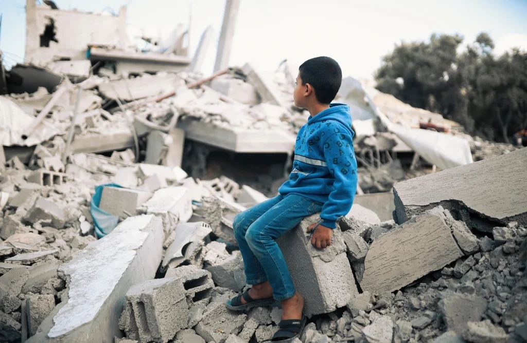boy in gaza rubble Boy sitting on rubble in gaza