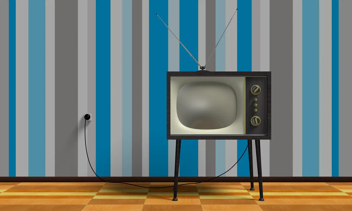 Retro television in a room with striped wallpaper and wooden floor. Broadcast licenses