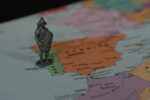 Small statue of ancient soldier on a world map. Declaration of war