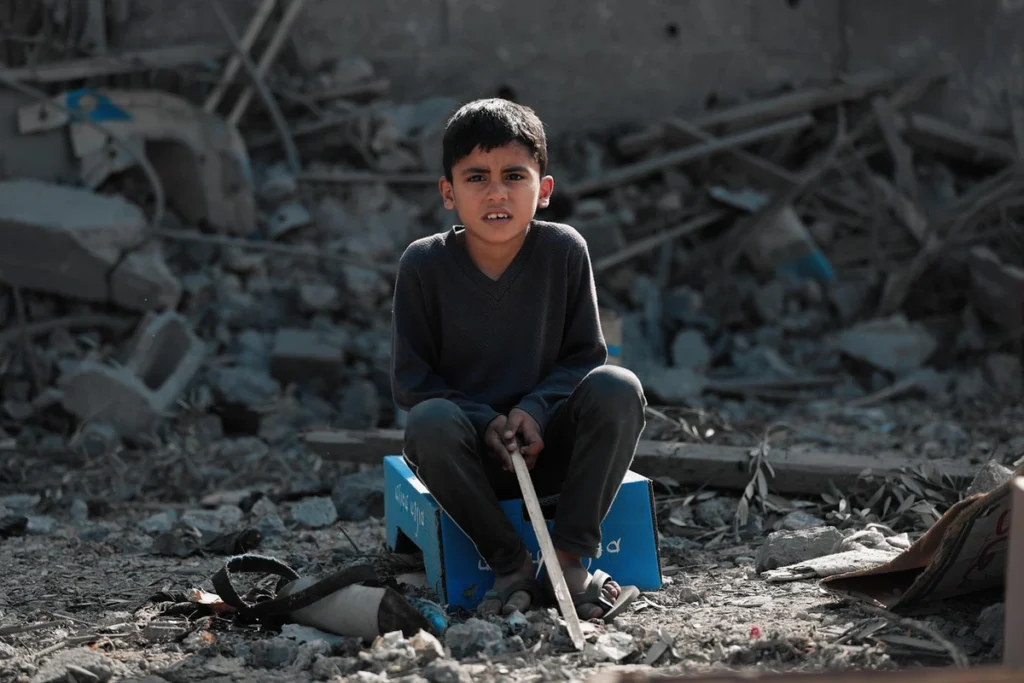 Rules of engagement have been ignored in gaza. A child sitting in the rubble.