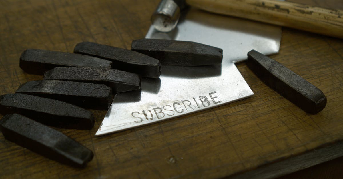Vintage letter stamps and hammer on wood surface with 'subscribe' on metal sheet.